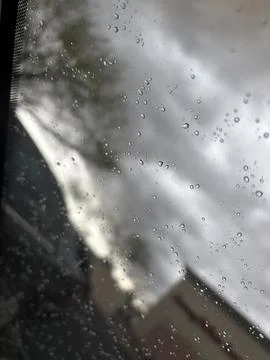 Abstract Raindrops on Window Glass with Dramatic Stormy Cloudy Sky Background Stock Photos