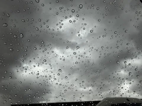 Abstract Raindrops on Window Glass with Dramatic Stormy Cloudy Sky Background Stock Photos