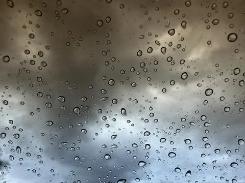 Abstract Raindrops on Window Glass with Dramatic Stormy Cloudy Sky Background Stock Photos