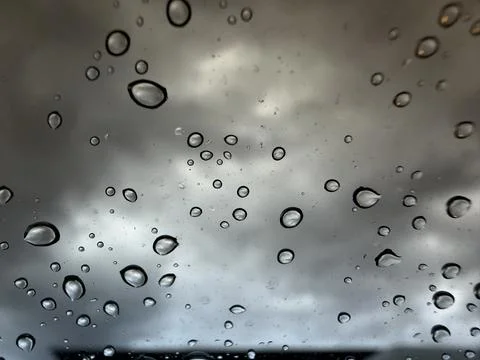 Abstract Raindrops on Window Glass with Dramatic Stormy Cloudy Sky Background Stock Photos