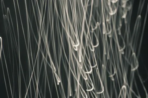 Abstract rays of sandy hue on a black background. Drawing with light. Chaos.  Stock Photos
