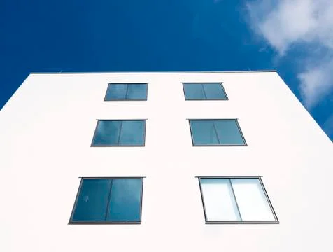Abstract rectangular forms of windows in white wall reflect blue sky and clou 스톡 사진