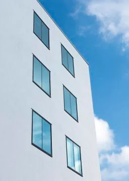 Abstract rectangular forms of windows in white wall reflect blue sky and clou Foto stock