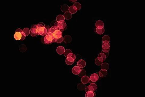 Abstract red bokeh light circles forming a delicate pattern against a dark .. Stock Photos