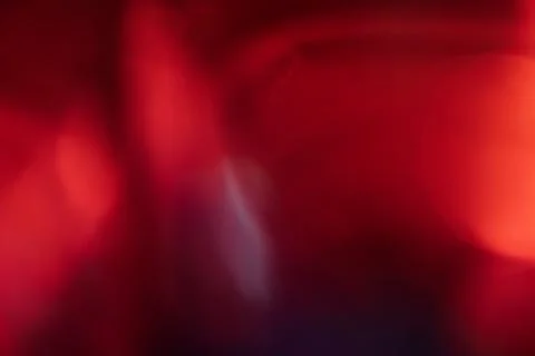 Abstract red light leak texture background against a dark backdrop. Illustrazione stock