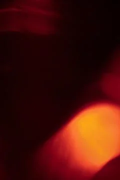 Abstract red light leak texture background against a dark backdrop. Stock Photos