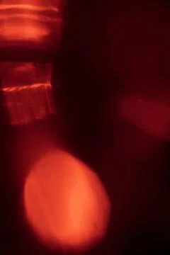 Abstract red light leak texture background against a dark backdrop. Stock Photos
