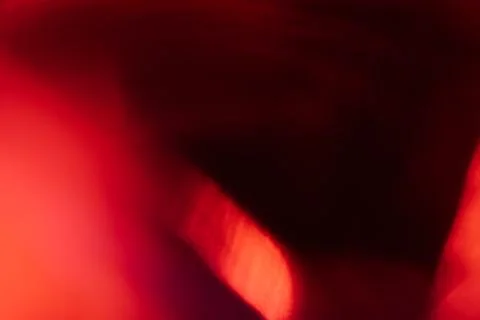 Abstract red light leak texture background against a dark backdrop. Stock Photos