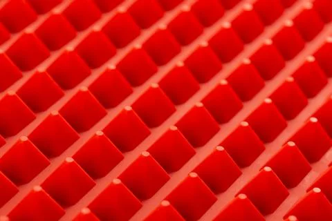 Abstract red silicone pyramids array close-up background Stock Photos