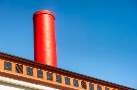 Abstract of a red smoke stack against blue sky 스톡 사진