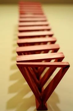 Abstract red wooden object with continuous and spaced triangular shape Foto stock