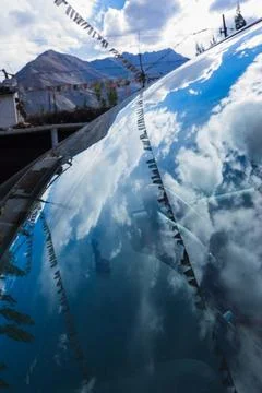 Abstract reflection of blue sky with white clouds and Himalayan mountains ove Stock Photos