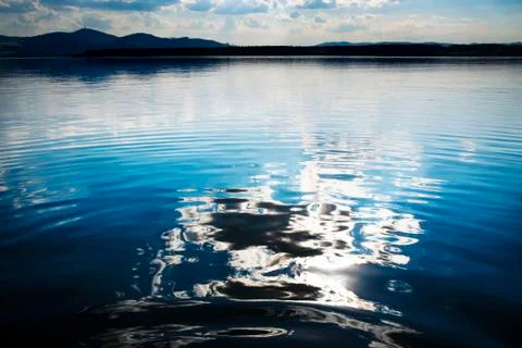 Abstract reflection of a cloud on a lake water surface Stock Photos
