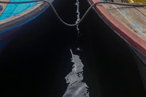 Abstract Reflection of Clouds Between Two Wooden Fishing Boats Stock Photos