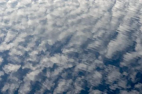 Abstract reflection of clouds on calm water surface Stockfoto's