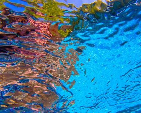 Abstract reflection from underneath blue pool water with ripples and distortion Stock Photos