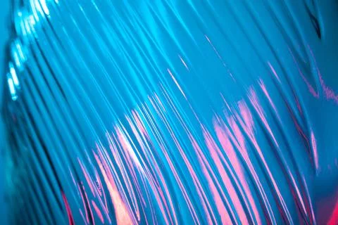 Abstract ribbed glass with wavy pattern illuminated in blue and pink light Stock Photos