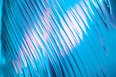 Abstract ribbed glass with wavy pattern illuminated in blue and pink light Stock Photos