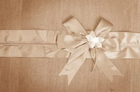 Abstract ribbon bow on fabric background. Stock Photos