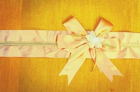 Abstract ribbon bow on fabric background. Stock Photos