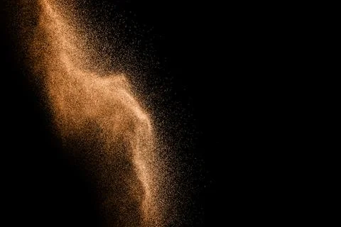 Abstract sand cloud.Brown sand splash against dark background. Brown dust. Stock Photos
