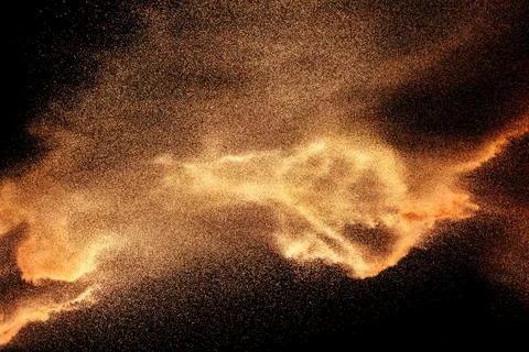Abstract sand cloud.Brown sand splash against dark background. Brown dust e.. Stock Photos