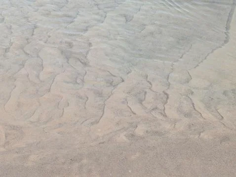 Abstract sand patterns under a thin layer of water Stock Photos