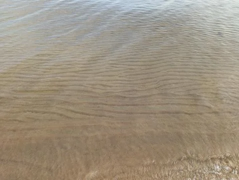 Abstract sand patterns under a thin layer of water Stock Photos