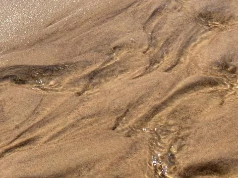 Abstract Sandy Water Texture with Sunlit Ripples and Reflections Stock Photos