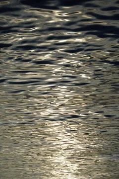 An abstract sea surface of gradient circular waves, glowing with silver and.. Stock Photos