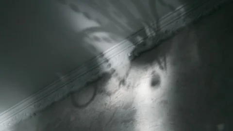 Abstract shadow of a classic chandelier moving on a textured wall with crown Video stock 337962099