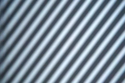 Abstract shadow pattern creates a interplay of light and shade on a wall surf Stock Photos