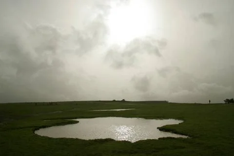 Abstract shape of pond on table land against sun setting and monsoon cloud... Foto stock