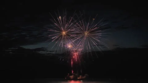 Abstract shot of exploding fireworks above the lake at night. Long exposure. Video stock 319827727