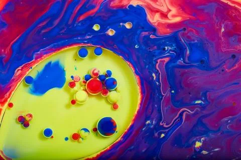 Abstract single celled organism in vibrant sea of swirling color oil paint Stock Photos
