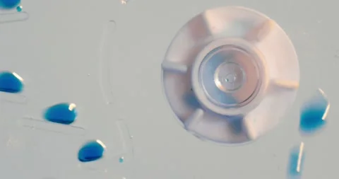Abstract Spinning Cog and Blue Chemical Drops Scientific Experiment Video stock 148223777