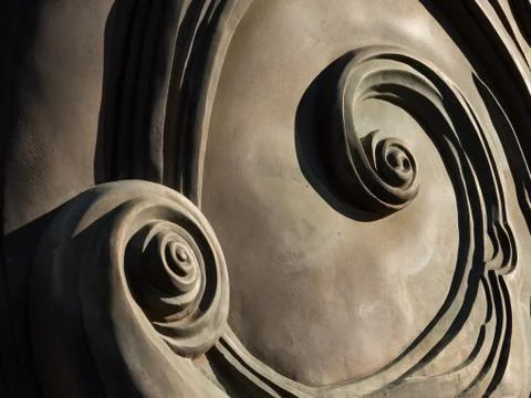 Abstract spirals at the back of a bronze monument Stock Photos