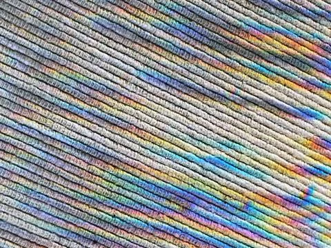 Abstract spotted rainbow pattern on a light textured cotton fabric. Backgrounds Foto stock