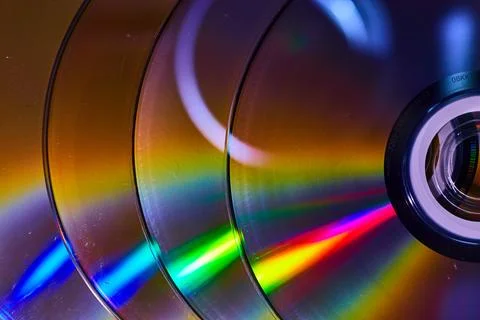 Abstract stack of four CDs with reflective rainbow cones of light 스톡 사진
