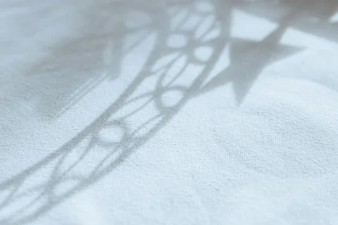 Abstract star shadow drawing on tablecloth. Stock Photos