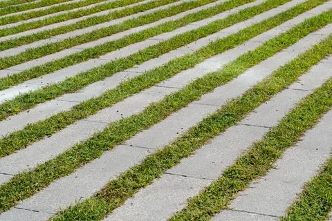Abstract striped texture of alternating concrete strips and green grass Stock Photos