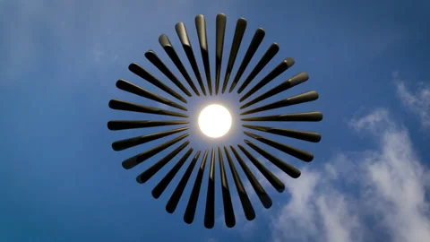 Abstract structure rotating in seamless loop around the sun with sky background. Stock Footage 205709975