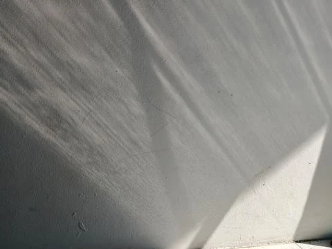 Abstract Sunlight Reflection and Window Shadows on White Concrete Wall Foto stock