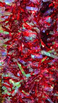 Abstract texture of bright red and iridescent metallic tinsel garland backg.. Stockfoto's