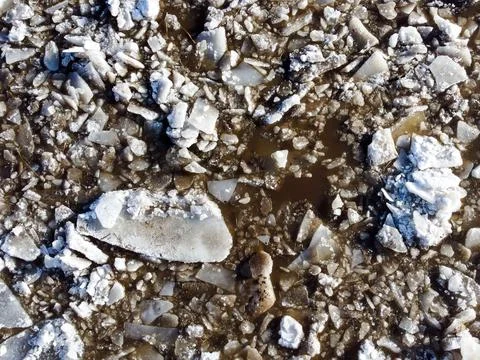 Abstract texture of broken white ice and dark water at winter. Stock Photos