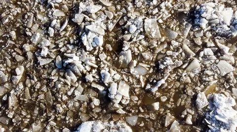 Abstract texture of broken white ice and dark water at winter. Spring is coming. Stock Photos
