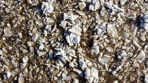 Abstract texture of broken white ice and dark water at winter. Spring is coming. Stock Photos