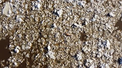 Abstract texture of broken white ice and dark water at winter. Spring is coming. Stock Photos