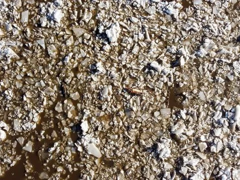 Abstract texture of broken white ice and dark water at winter. Spring is coming. Stock Photos
