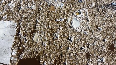 Abstract texture of broken white ice and dark water at winter. Spring is coming. Stock Photos